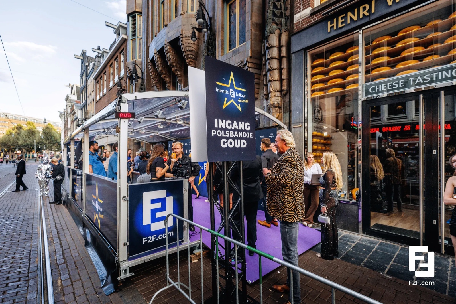 The entrance of an award show on an Amsterdam street: a purple carpet, a sign for the gold wristband entrance and a door team checking guests in on their phones