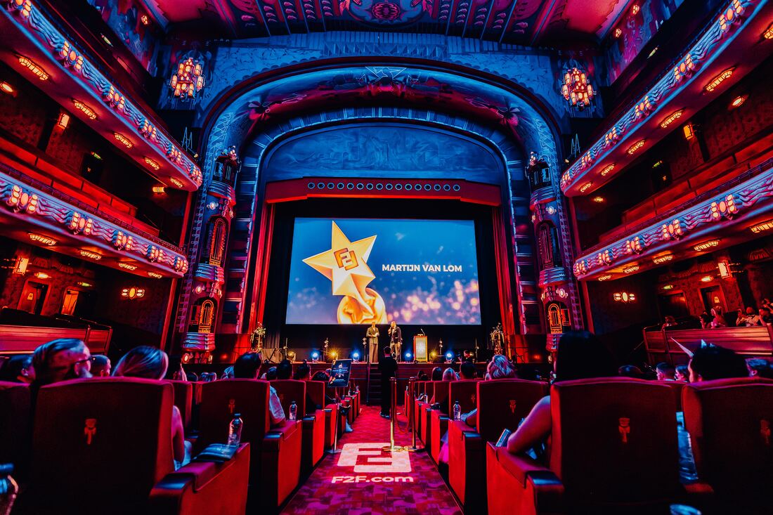The auditorium of Theater Tuschinski on the night of the F2F Creator Awards 2026: red seats, guests in the stalls and the awards logo on the screen above the stage
